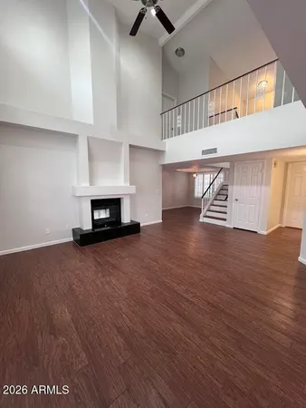 a view of a livingroom with wooden floor and a ceiling fan