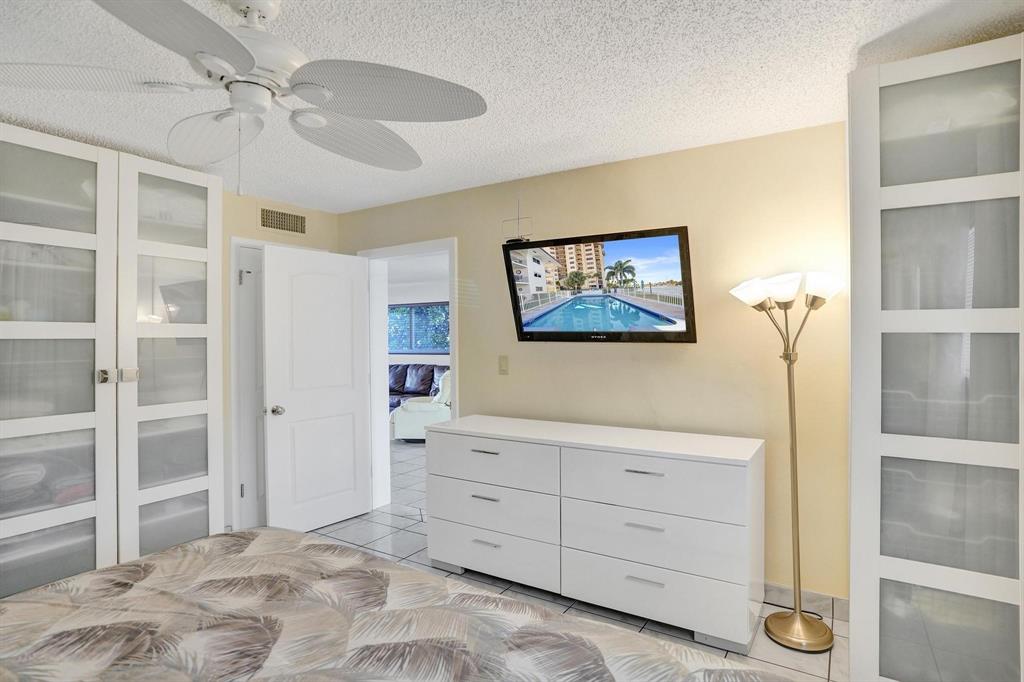 505 North Riverside Drive, Unit 7 Pompano Beach, FL 33062 - Photo 14 of 43 a bedroom with a bed and a chandelier