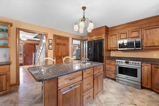a kitchen with stainless steel appliances granite countertop a stove and cabinets