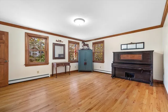 a view of an empty room with furniture and a window