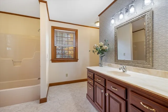 a bathroom with a sink a large mirror and a bathtub