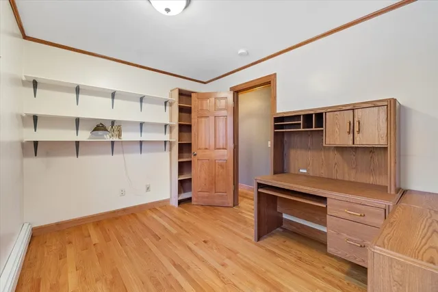 a view of empty room with wooden floor and cabinet