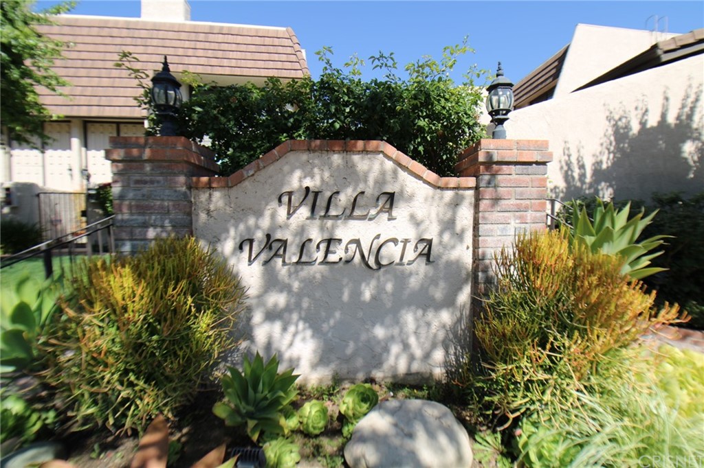 a view of a sign in a yard with potted plants