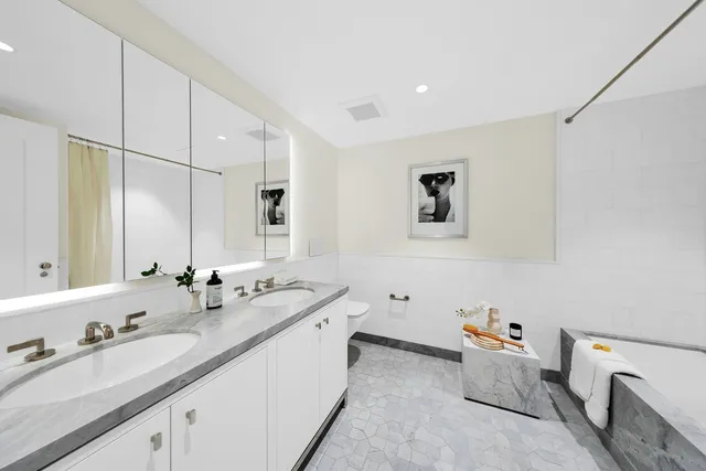 a bathroom with a double vanity sink a mirror and a bathtub