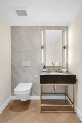 a bathroom with a sink a toilet and mirror
