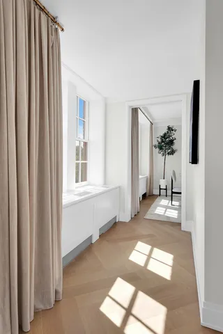 a view of a hallway with furniture and a window