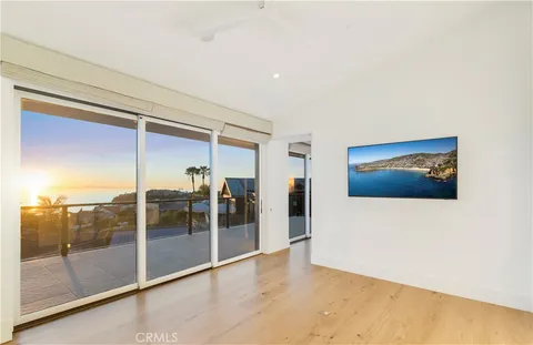 a view of a hallway with wooden floor and cabinet