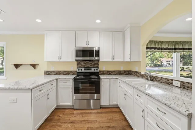 a kitchen with granite countertop a stove and a sink