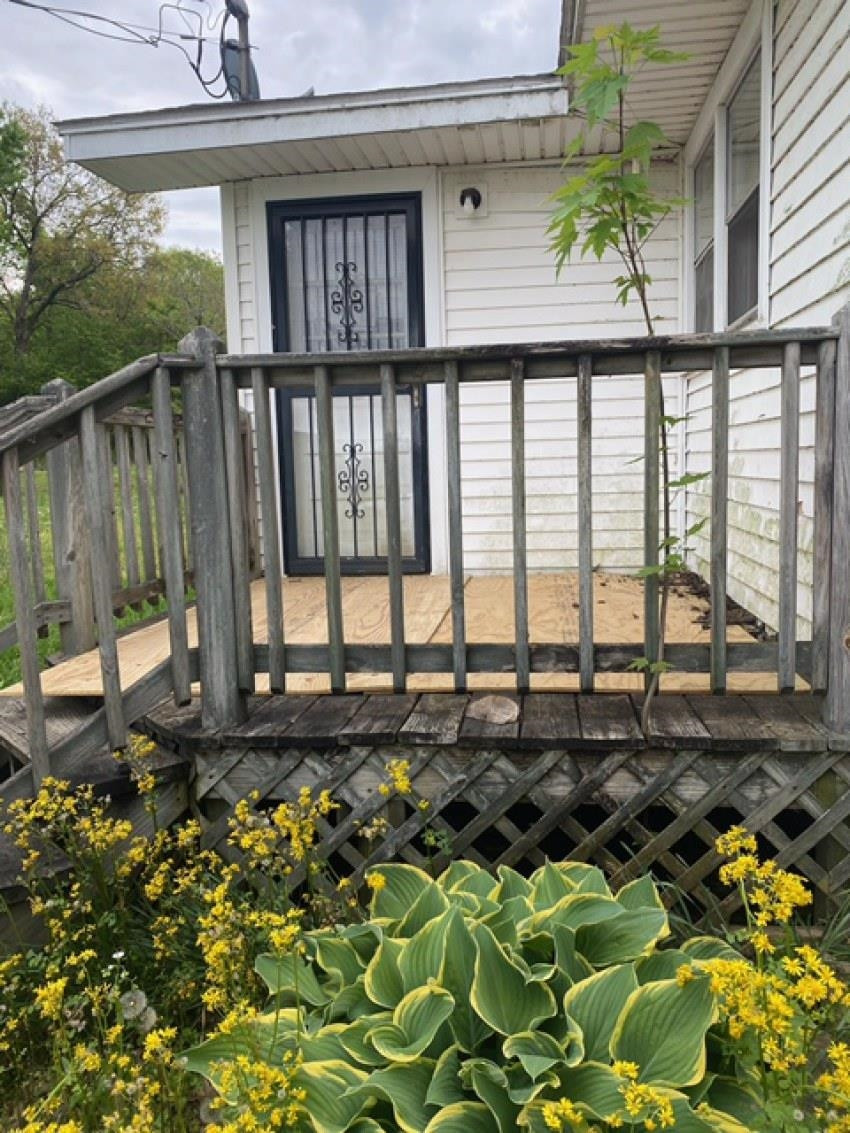 700 Pilgrims Rest Road McKenzie, TN 38201 - Photo 3 of 13 a view of a porch with a floor to ceiling window and potted plants