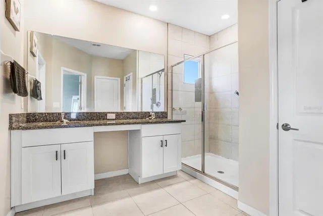 a bathroom with a shower sink and mirror