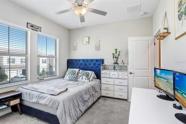 a bedroom with a bed a dresser and next to a window