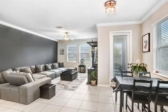 a living room with furniture a chandelier and a dining table