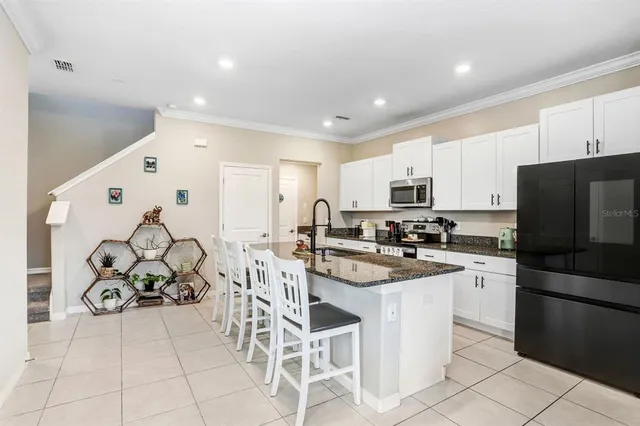 a kitchen with white cabinets and stainless steel appliances