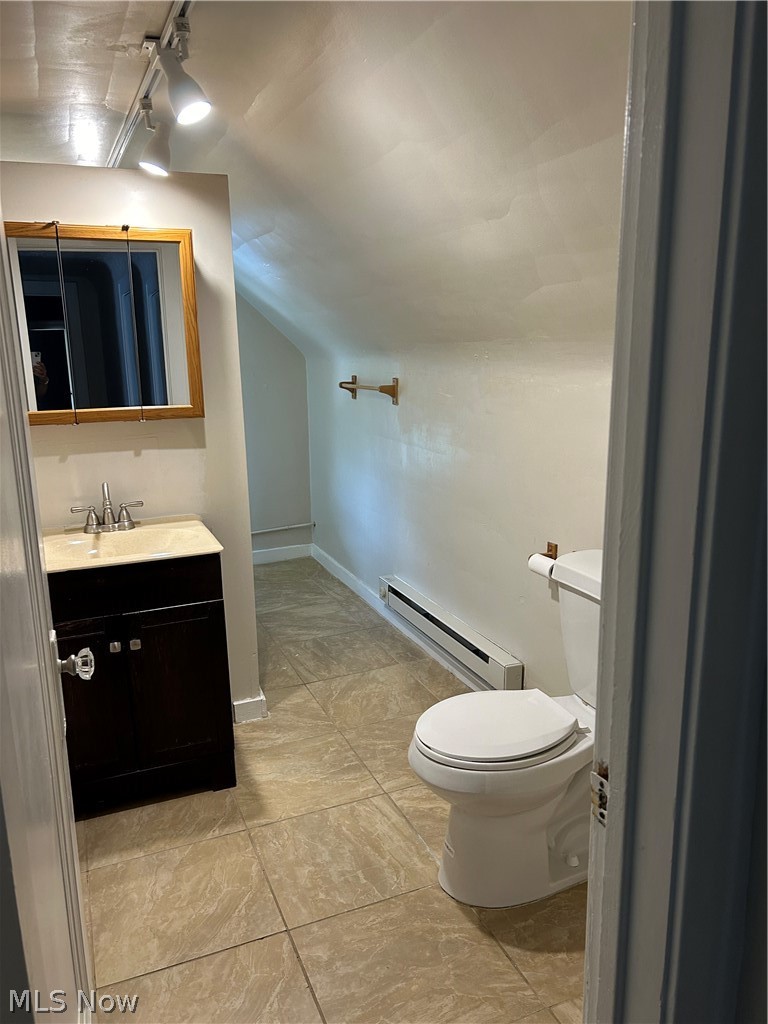 3658 Strathavon Road Cleveland, OH 44120 - Photo 10 of 16 Bathroom featuring lofted ceiling, toilet, vanity, tile patterned floors, and a baseboard radiator