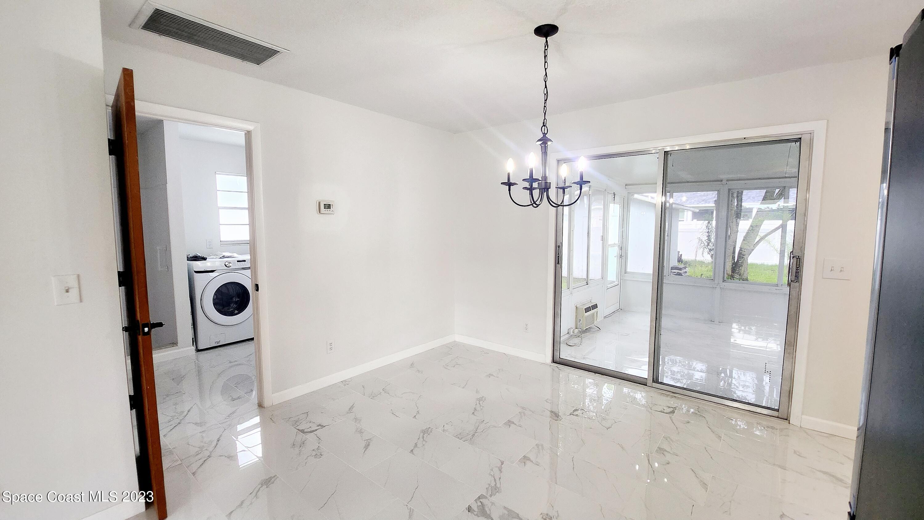 925 Gulfstream Avenue Sebastian, FL 32958 - Photo 5 of 19 a view of a hallway with a chandelier fan and glass door