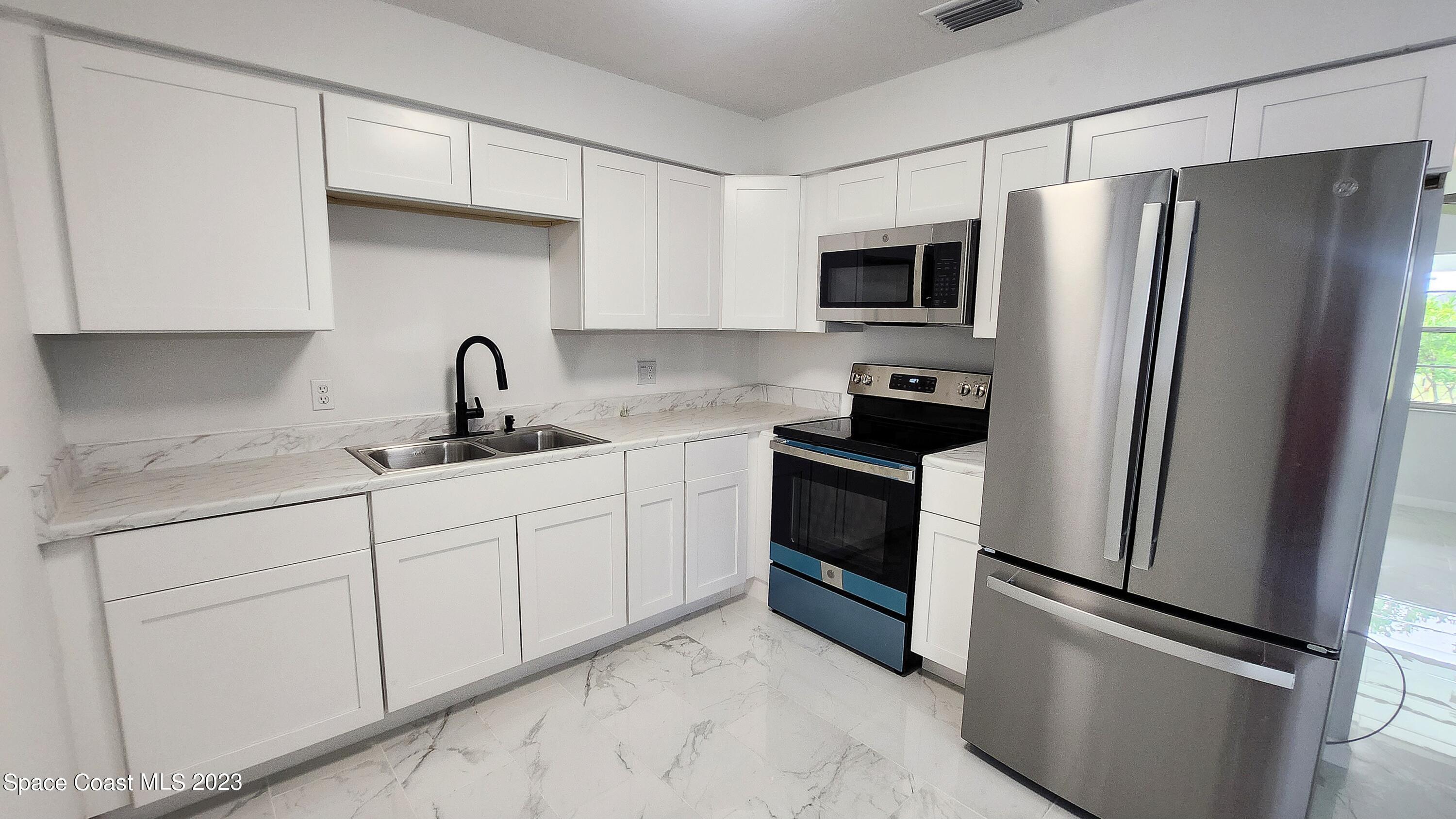 925 Gulfstream Avenue Sebastian, FL 32958 - Photo 6 of 19 a kitchen with stainless steel appliances a refrigerator sink and cabinets
