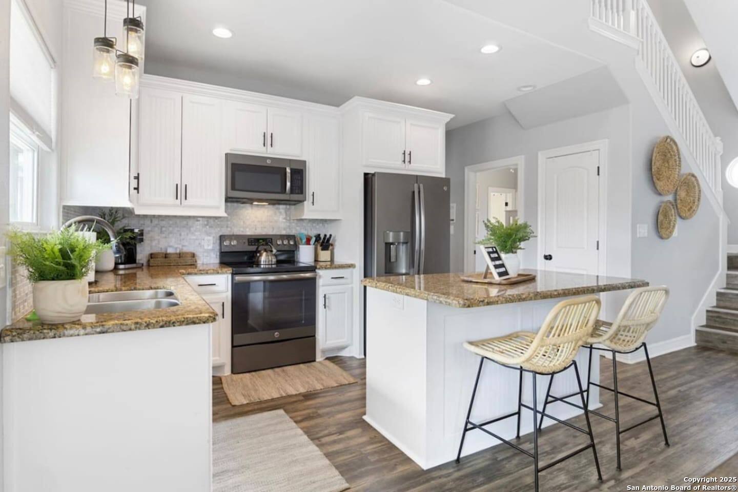 972 Surf Road Crystal Beach, TX 77650 - Photo 2 of 18 a kitchen with a refrigerator a stove a sink a dining table and chairs with wooden floor