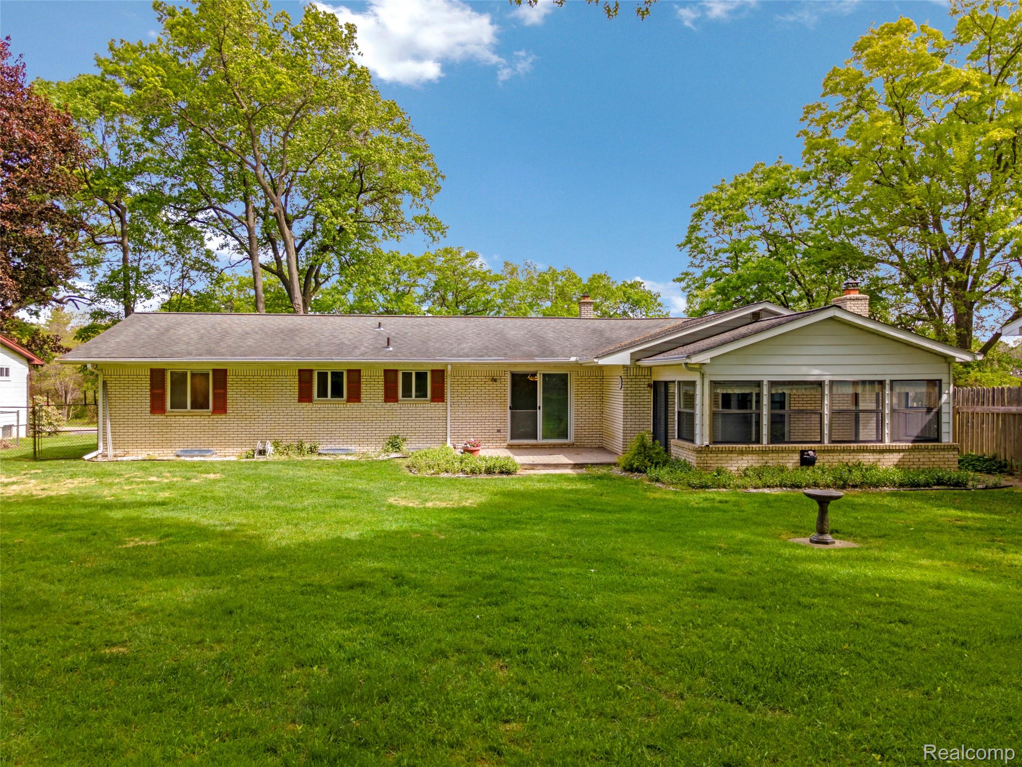 8887 Clark Road Clarkston, MI 48346 - Photo 28 of 40 View of front facade with brick siding, a sunroom, and a chimney