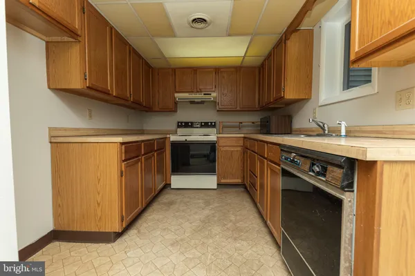 a kitchen with stainless steel appliances granite countertop a stove a sink dishwasher and a refrigerator