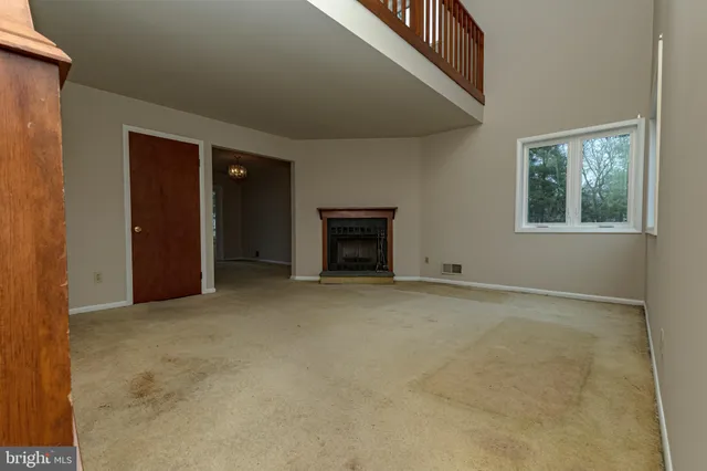 an empty room with windows and fireplace