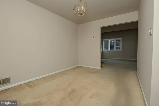 an empty room with chandelier fan
