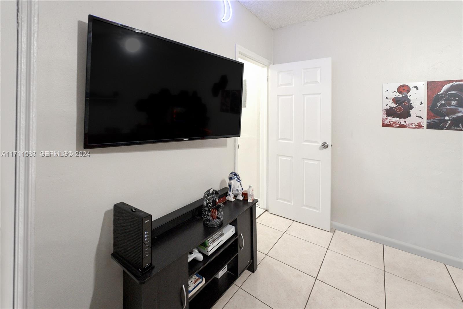 175 Northwest 68th Street Miami, FL 33150 - Photo 7 of 31 a living room with a flat screen tv and a stove