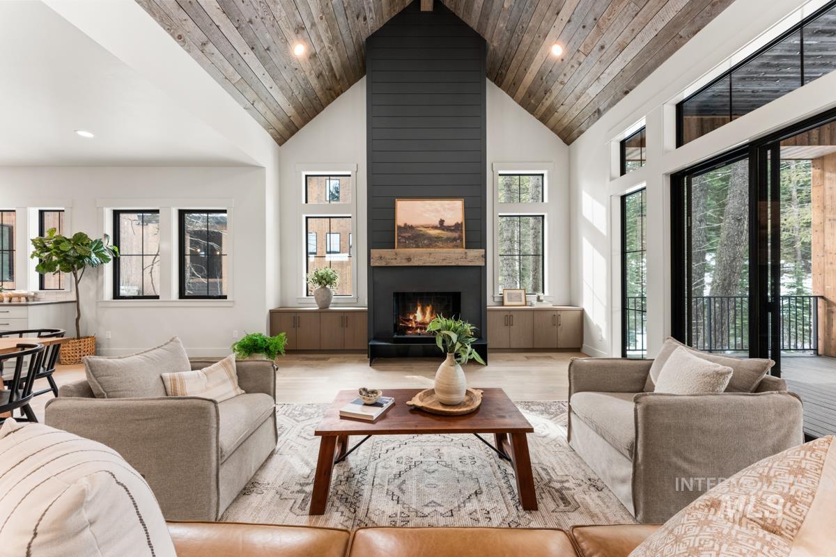 Living room with a high wood ceiling, wood finished floors, a fireplace, plenty of natural light, and recessed lighting