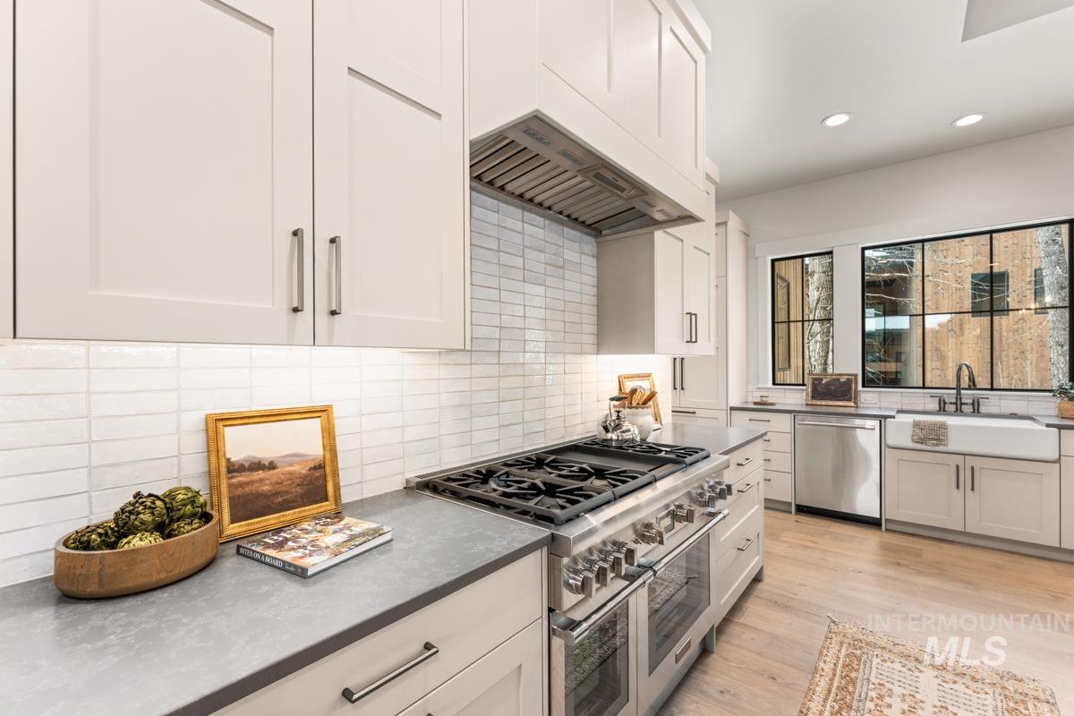 68 Ponderosa Ridge Donnelly, ID 83615 - Photo 18 of 29 Kitchen featuring stainless steel appliances, decorative backsplash, light wood-type flooring, recessed lighting, and white cabinets