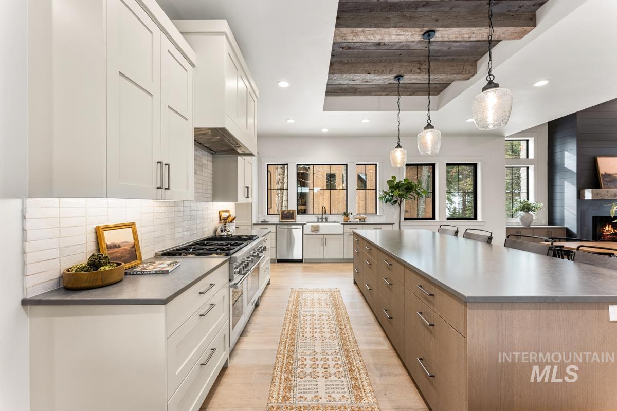 68 Ponderosa Ridge Donnelly, ID 83615 - Photo 2 of 29 Kitchen with two tone color scheme, stainless steel appliances, a raised ceiling, dark countertops, and light wood-style floors