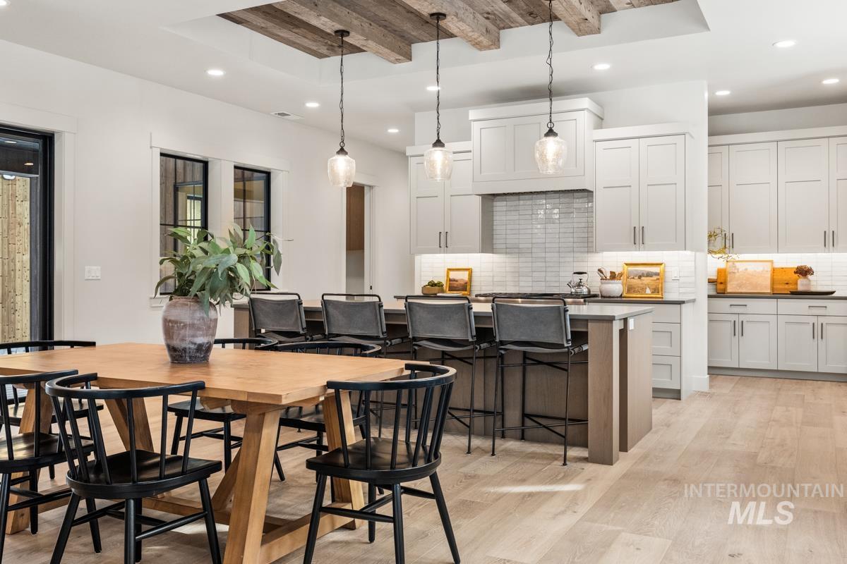 68 Ponderosa Ridge Donnelly, ID 83615 - Photo 21 of 29 Kitchen with beam ceiling, dark countertops, light wood-type flooring, pendant lighting, and a breakfast bar
