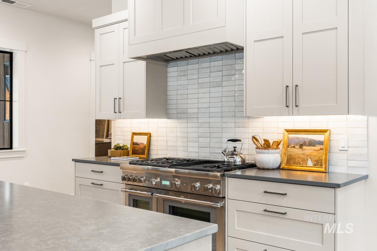 68 Ponderosa Ridge Donnelly, ID 83615 - Photo 23 of 29 Kitchen with range with two ovens, white cabinets, and tasteful backsplash