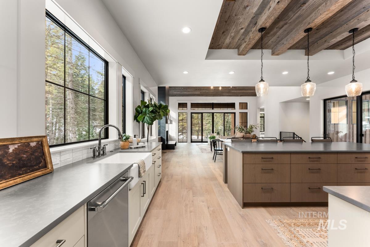 68 Ponderosa Ridge Donnelly, ID 83615 - Photo 29 of 29 Dual tone kitchen featuring dark countertops, stainless steel dishwasher, open floor plan, light wood-type flooring, and a wood ceiling with exposed beams