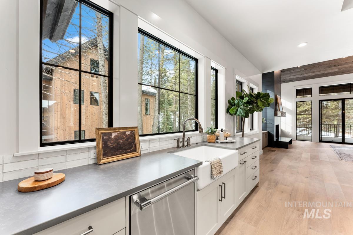 68 Ponderosa Ridge Donnelly, ID 83615 - Photo 26 of 29 Kitchen featuring stainless steel dishwasher, light wood-type flooring, backsplash, recessed lighting, and white cabinetry