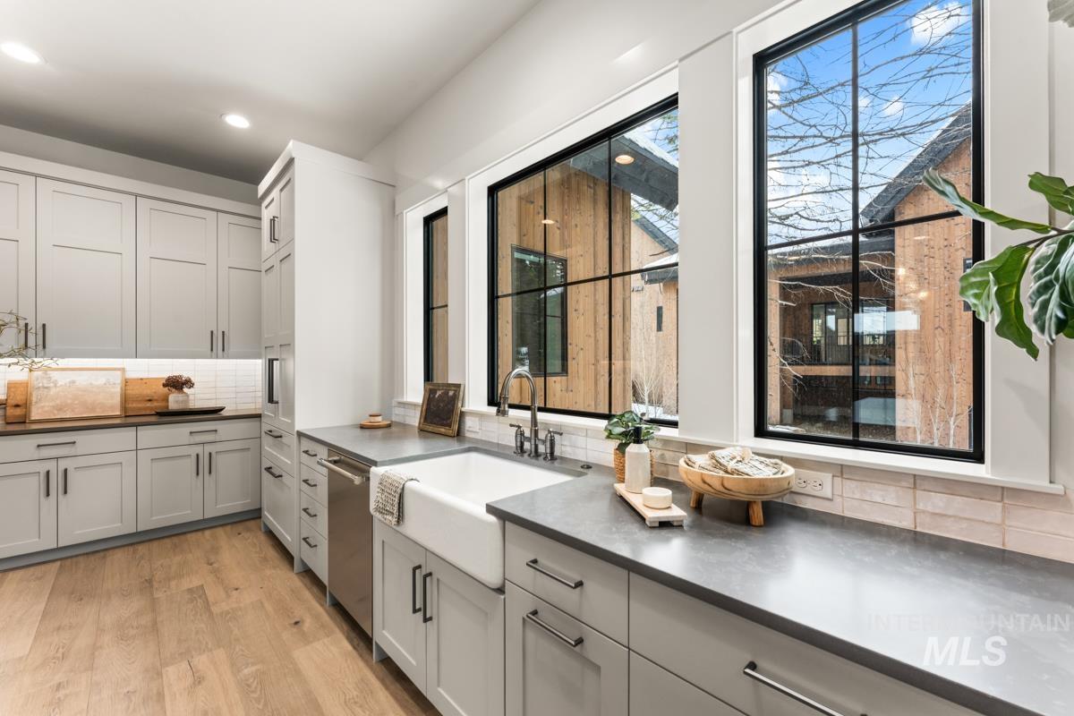 68 Ponderosa Ridge Donnelly, ID 83615 - Photo 27 of 29 Kitchen featuring dark countertops, decorative backsplash, light wood-style floors, and dishwasher