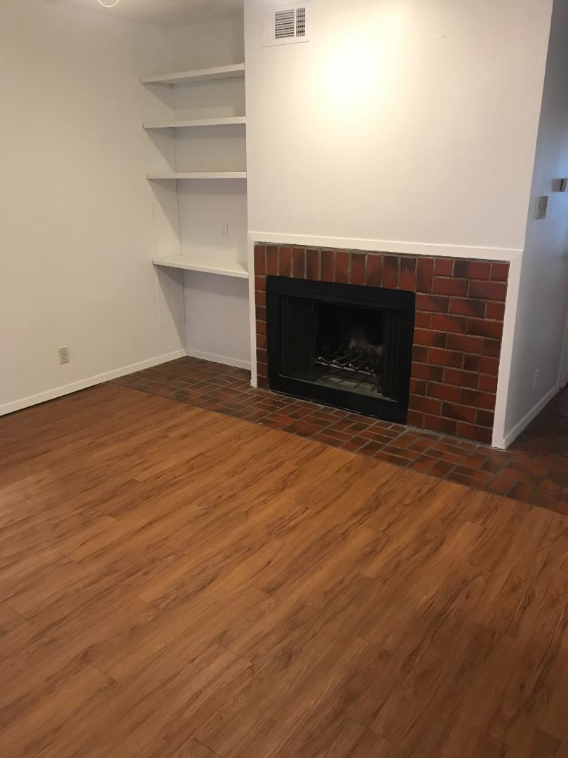 2110 Rio Grande Street, Unit 303 Austin, TX 78705 - Photo 2 of 7 A cozy gathering spot with a fireplace and built-in shelving.