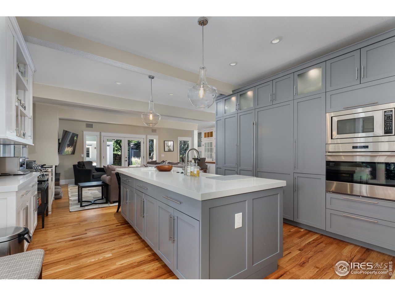 421 Highland Avenue Boulder, CO 80302 - Photo 9 of 39 a large kitchen with kitchen island a stove a sink dishwasher oven a dining table and chairs with wooden floor