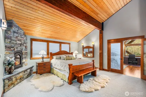 a bedroom with a bed and large windows