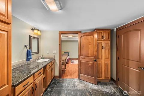 a bathroom with a granite countertop sink and a mirror