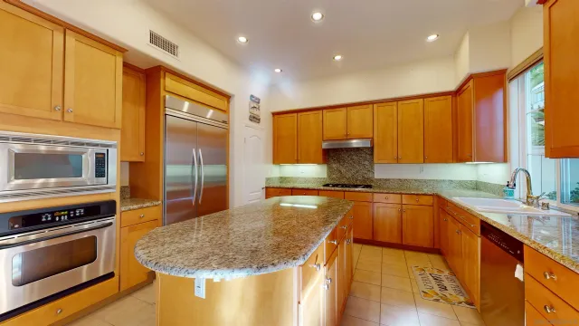a kitchen with stainless steel appliances granite countertop a sink stove and refrigerator