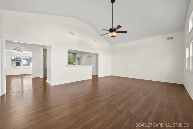 a view of an empty room with window and wooden floor