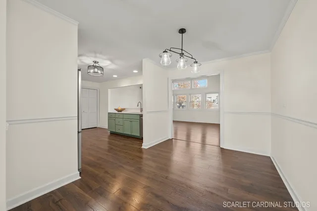 a view of a hallway with wooden floor and a kitchen