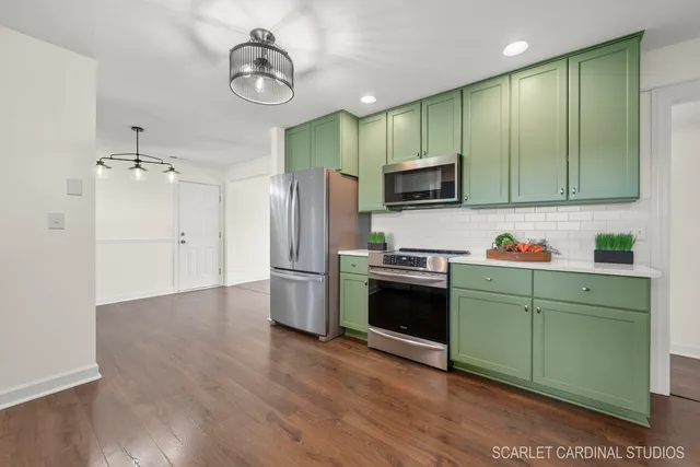 a kitchen with a refrigerator and a stove top oven