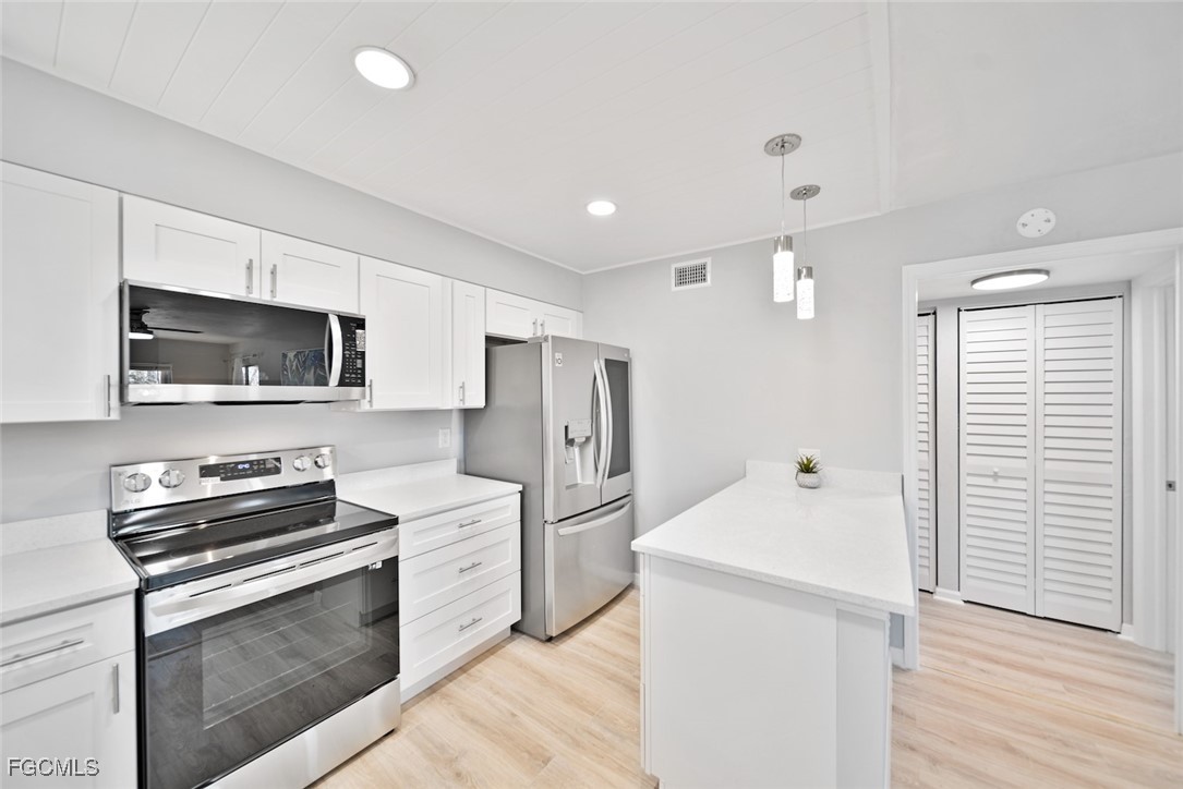 16881 Davis Road, Unit 721 Fort Myers, FL 33908 - Photo 8 of 23 a kitchen with a refrigerator stove and microwave