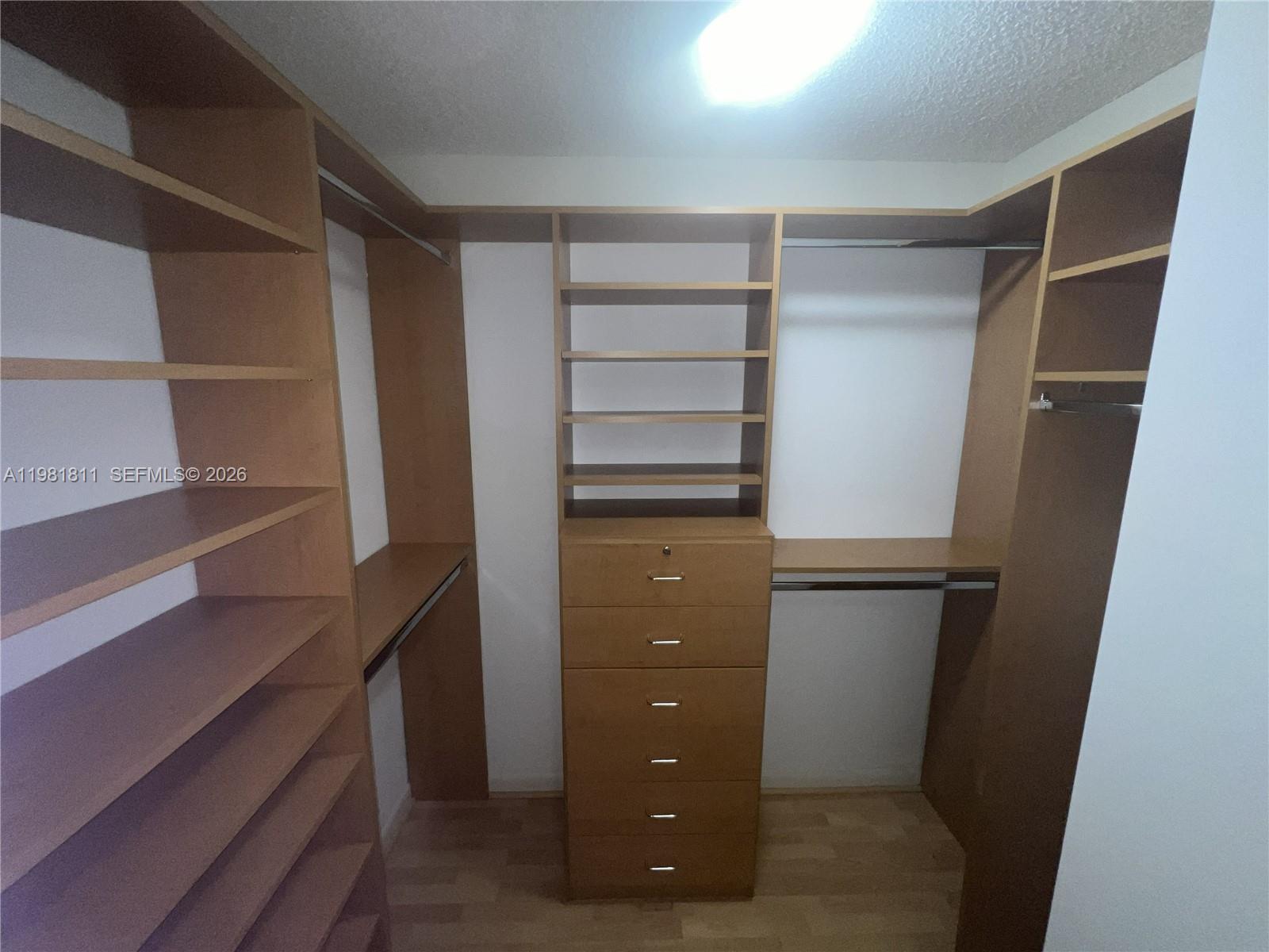 8816 Collins Avenue, Unit 105 Surfside, FL 33154 - Photo 13 of 30 a view of walk in closet with empty racks