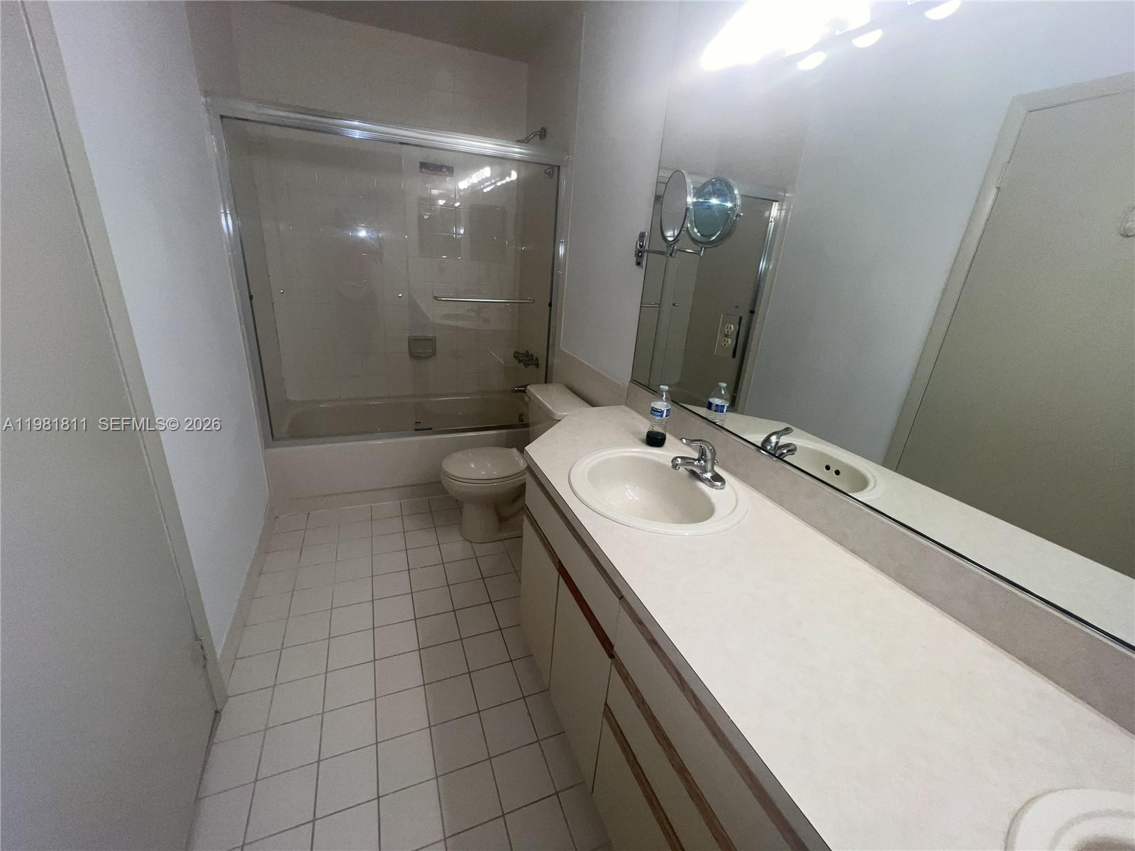 8816 Collins Avenue, Unit 105 Surfside, FL 33154 - Photo 17 of 30 a bathroom with a sink a toilet a mirror and shower