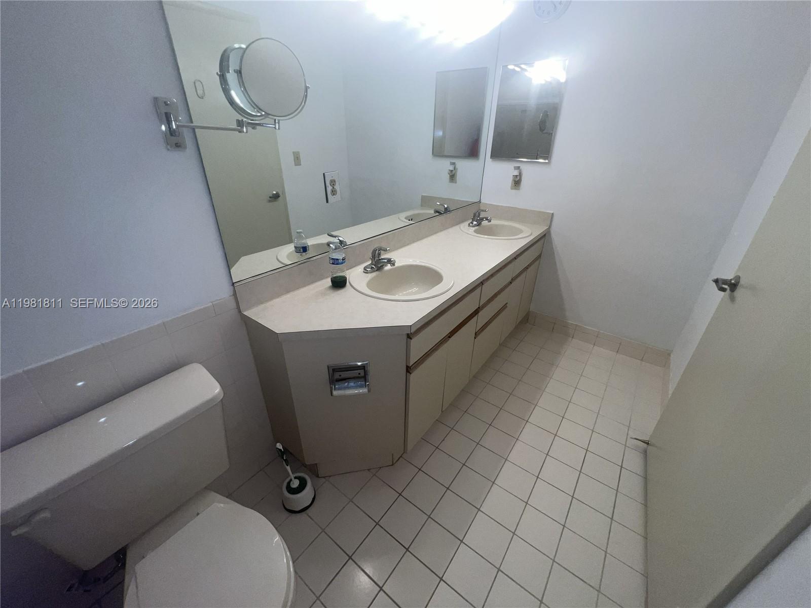 8816 Collins Avenue, Unit 105 Surfside, FL 33154 - Photo 18 of 30 a bathroom with a sink mirror vanity and toilet