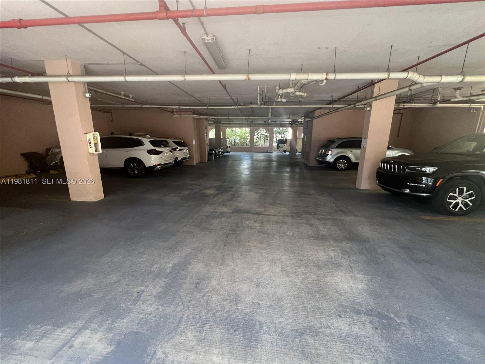 8816 Collins Avenue, Unit 105 Surfside, FL 33154 - Photo 29 of 30 a view of parking garage with cars