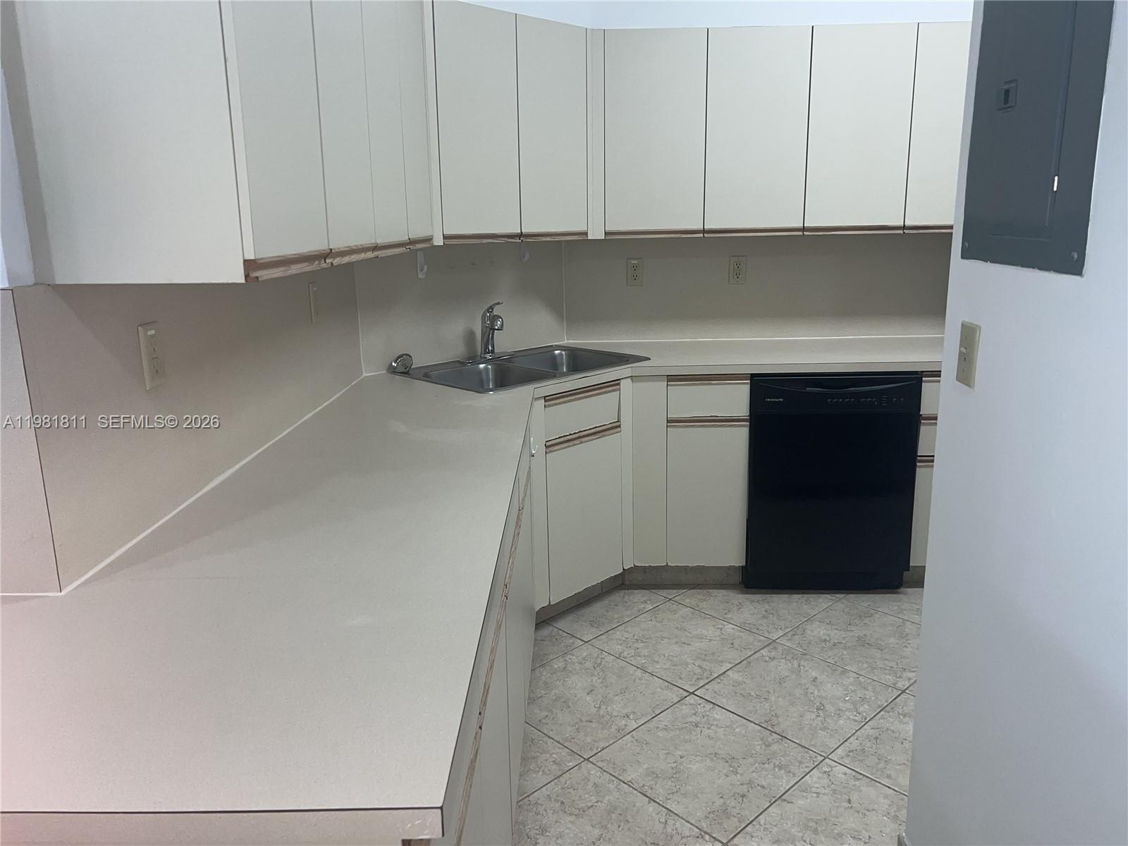 8816 Collins Avenue, Unit 105 Surfside, FL 33154 - Photo 7 of 30 a kitchen with a sink and cabinets
