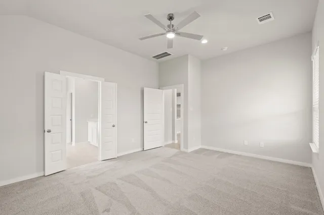 an empty room with a ceiling fan and a window