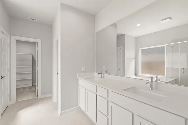 a bathroom with double sink and a mirror